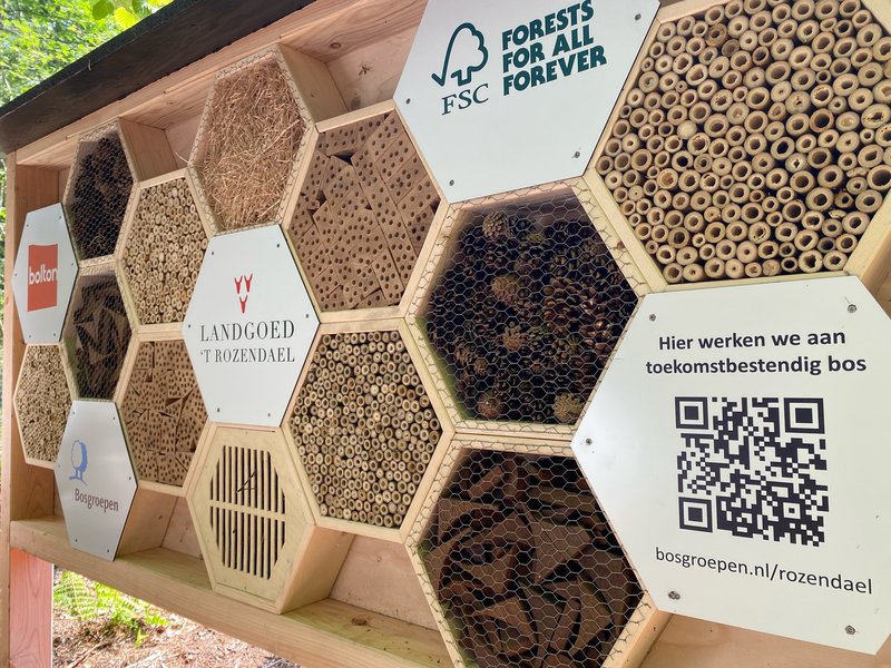 Het insectenhotel op het landgoed; de QR-code verwijst naar de projectpagina met meer informatie.