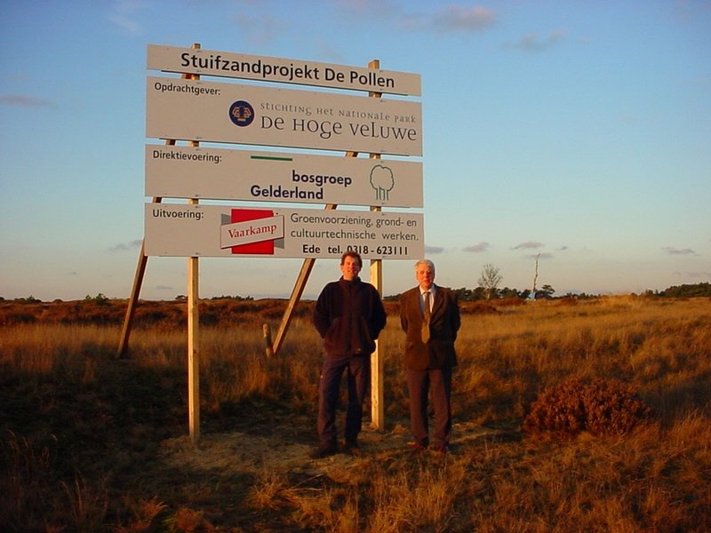Twee personen voor een projectbord op het stuifzand