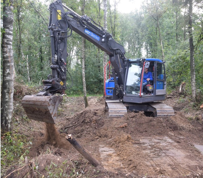 graafmachine voert werkzaamheden uit in het bos.